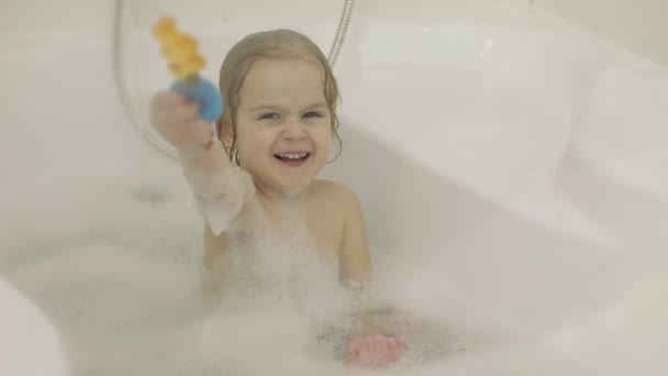 Привлекательная трехлетняя девочка принимает ванну. Посыпать водой в камеру — стоковое видео