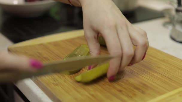 Femme au foyer mains tranchant concombre mariné en morceaux dans la cuisine — Video