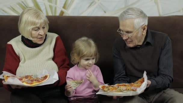 Hermoso anciano hombre y mujer come pizza con su nieta — Vídeos de Stock