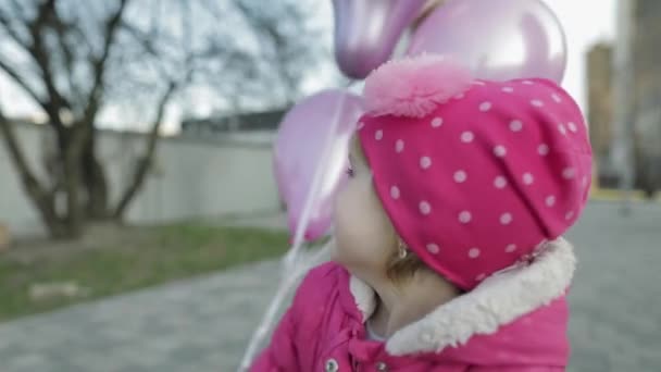 Glad söt barn på gatan med ballonger med helium. Födelsedagsfest — Stockvideo