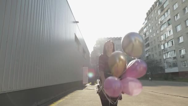 Vacker kvinna i klänning innehav ballonger med helium utomhus i dagsljus — Stockvideo