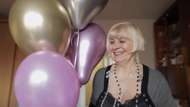 Cute grandma celebrates her birthday. Holds multicolored balloons in her hands — Stock Video