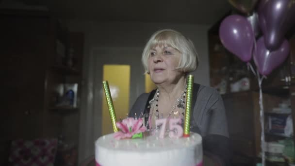 Feliz anciana sosteniendo pastel. Celebrando. Soplando velas de cumpleaños — Vídeos de Stock