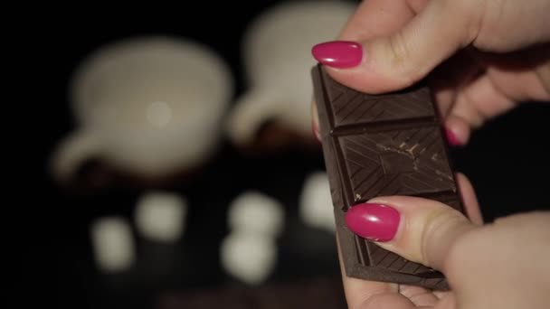 Una donna rompe la barretta di cioccolato nero. Primo piano. Rallentatore — Video Stock