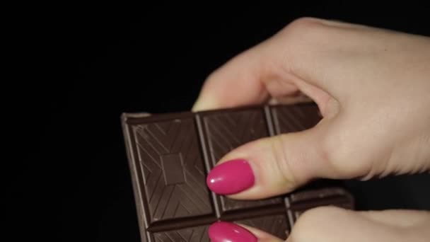 Una donna rompe la barretta di cioccolato nero. Primo piano. Rallentatore — Video Stock