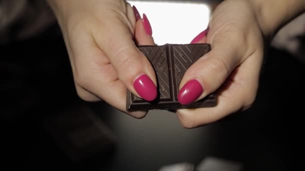 Una donna rompe la barretta di cioccolato nero. Primo piano. Rallentatore — Video Stock