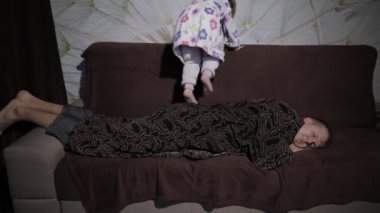 Küçük kız babası uyanma bornoz. Adam Kanepede uyur