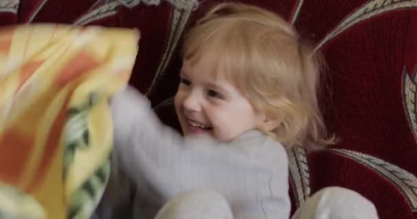 Close-up de um rosto menina bonita loira pouco. Uma rapariga a sorrir. Lá dentro. Retrato tirado — Vídeo de Stock