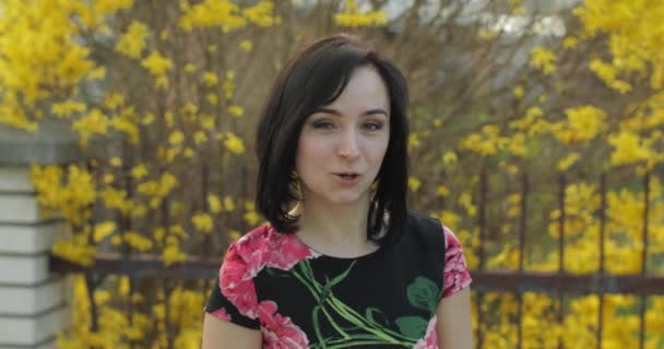 Komik yüzler yapma çiçekler ile bir elbise çekici genç kadın — Stok video