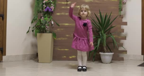 植木鉢と木製のフェンスの近くの小さな子供のダンス.幸せを感じる, 笑顔 — ストック動画