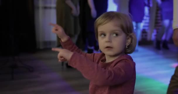 Uma dança infantil na pastelaria. Sente-te feliz, a sorrir. Menina se divertindo na discoteca — Vídeo de Stock