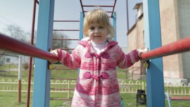 Engraçado bonito menina está jogando. Joyous criança feminina se divertindo no parque infantil — Vídeo de Stock