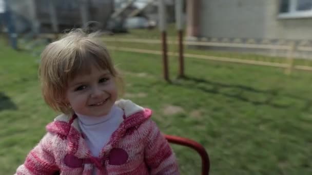 Lustiges nettes Mädchen spielt. fröhliches weibliches Kind hat Spaß auf Spielplatz — Stockvideo