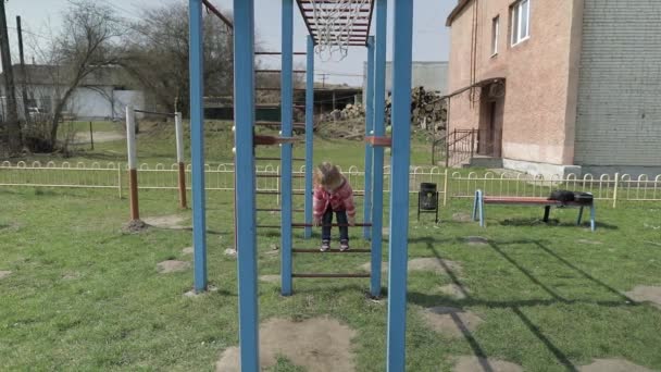 Drôle de fille mignonne joue. Joyeuse enfant femelle s'amusant sur l'aire de jeux — Video