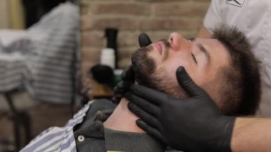 Berber dükkanında sakal tıraş sırasında siyah sakal ile müşteri. Damat, erkeksi