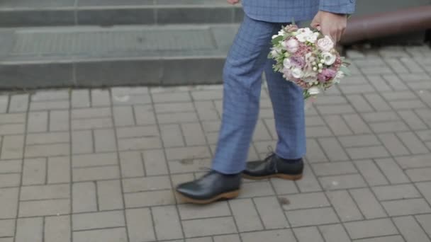 Coucou marchant vers sa mariée tenant le bouquet de mariage à la main. Mouvement lent — Video