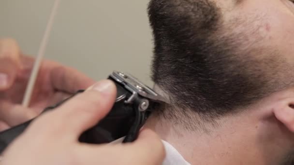 Kundin mit schwarzem Bart beim Bartrasieren im Friseursalon. Bräutigam, männlich — Stockvideo