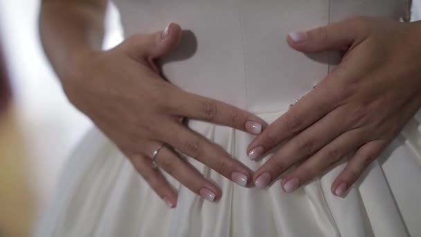 Bruid in trouwjurk. Hand raakt jurk. Mooie en goed verzorgde vrouw — Stockvideo