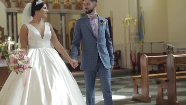 Elegant bride and groom walking together in an old church. Wedding couple — Stock Video