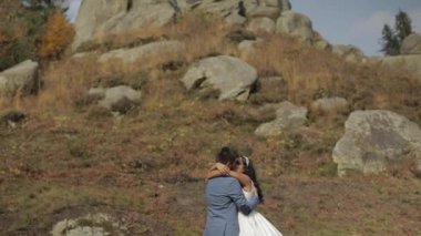 Dağ tepeleri yakınında gelin ile damat. Düğün çifti. Sevgi içinde mutlu bir aile