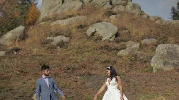 Γαμπρός με νύφη κοντά σε λόφους. Ζευγάρι γάμων. Ευτυχισμένη οικογένεια στην αγάπη — Αρχείο Βίντεο