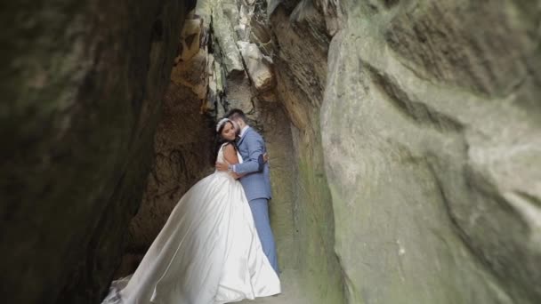Brilho com noiva em pé na caverna de colinas de montanha. Casamento casal apaixonado — Vídeo de Stock