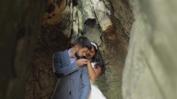 Vőlegény a menyasszony álló barlangban a hegyi hegyek. Esküvői pár szerelmes — Stock videók
