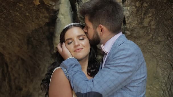 Sposo con sposa in piedi in grotta di colline di montagna. Matrimonio coppia innamorata — Video Stock