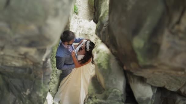 Bräutigam mit Braut, die in der Höhle der Berge steht. Hochzeitspaar verliebt