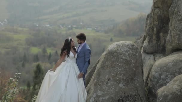 Vőlegény a menyasszony egy hegyi dombok az erdőben. Nászpár — Stock videók