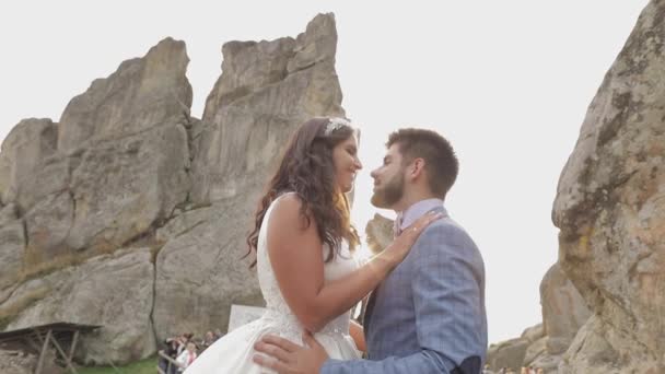 Vőlegény a menyasszony közelében hegyi dombok. Esküvői pár szerelmes. Napsugarak — Stock videók