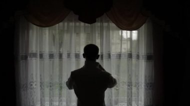 Yakışıklı damat gömleğini düzeltir. Düğün sabahı. Siluet. Yavaş hareket