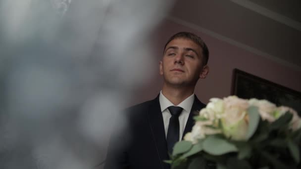 Sposo con la barba nera con bouquet da sposa per strada. Giorno del matrimonio — Video Stock