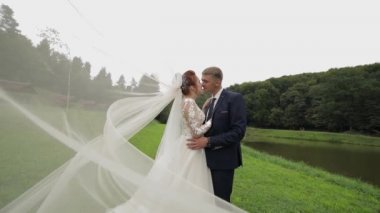 Parkta göl yakınında gelin peçe gelin ile damat. Düğün Çift