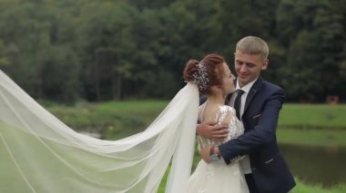 Parkta göl yakınında gelin peçe gelin ile damat. Düğün Çift