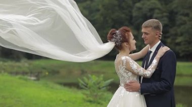 Parkta göl yakınında gelin peçe gelin ile damat. Düğün Çift