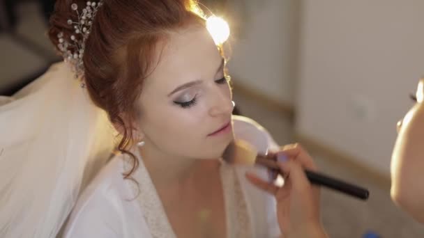 Artista de maquillaje de boda haciendo un maquillaje para la novia en el velo. Hermosa modelo sexy — Vídeos de Stock