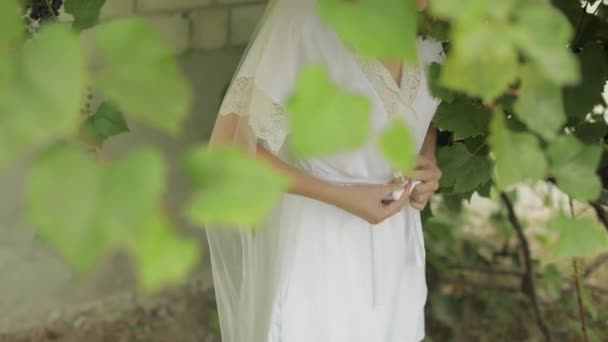 Hermosa y encantadora novia en vestido de noche y velo en el jardín. Mañana de boda — Vídeos de Stock