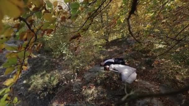 Brudgummen med bruden ligga ner i skogen parken. Bröllops paret. Lycklig familj — Stockvideo