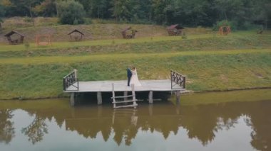 Parkta göl yakınında gelin ile damat. Düğün çifti. Hava atışı
