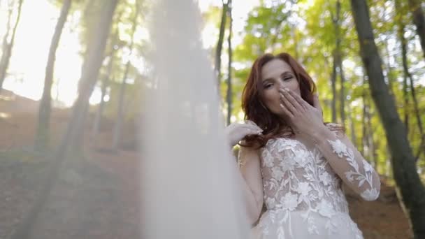 Menyasszony esküvői ruha fátyolon az erdei parkban. boldog. Szerelmes nő — Stock videók