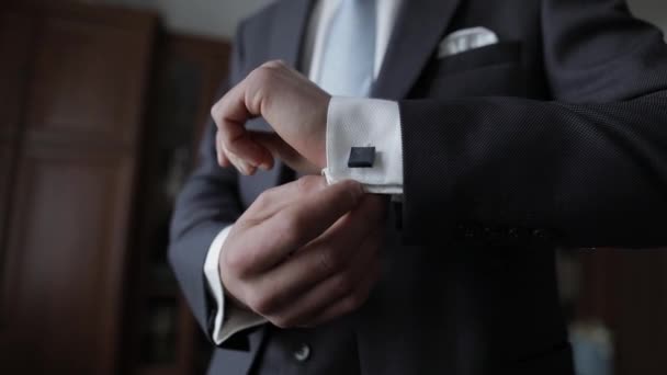 Schöner Bräutigam fixiert seine Manschetten an einer Jacke mit Manschettenknöpfen. Geschäftsmann — Stockvideo