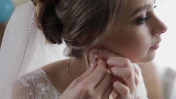 Elegante novia rubia usar hermosos pendientes. Mujer en la mañana de bodas — Vídeos de Stock