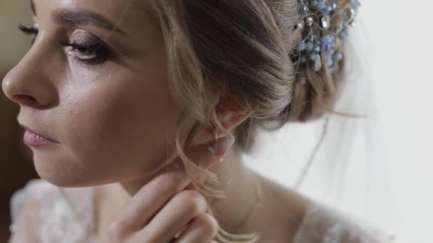 Elegante sposa bionda indossare bellissimi orecchini. Donna al mattino di nozze — Video Stock