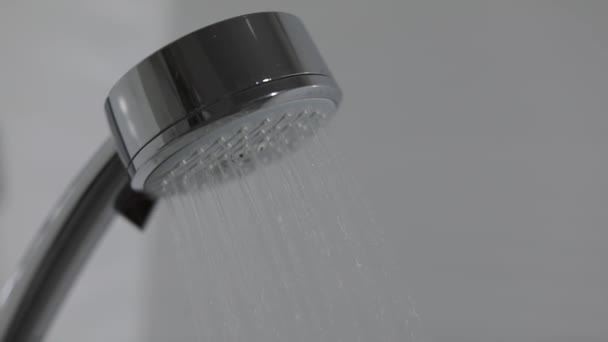 Duschmunstycke i badrum med vattendroppar flyter. Vattendroppar i duschmunstycke — Stockvideo