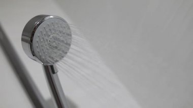 Su damlaları akan banyoda duş kafası. Duş başlığında su damlaları