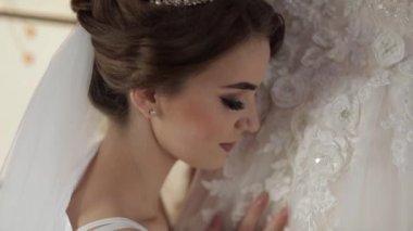 Gece elbisesi güzel ve güzel gelin gelinlik yakınında duruyor. Düğün
