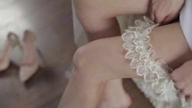 Gece elbisesi içinde güzel ve güzel gelin. Bacaktaki jartiyer giyinmek