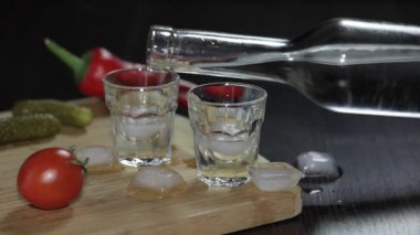 Buz küpleri ile shot bardak içine bir şişe votka dökün