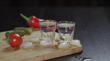 Rustik tahtadaki bardaklarda votka. Buz küpleri ekleme.